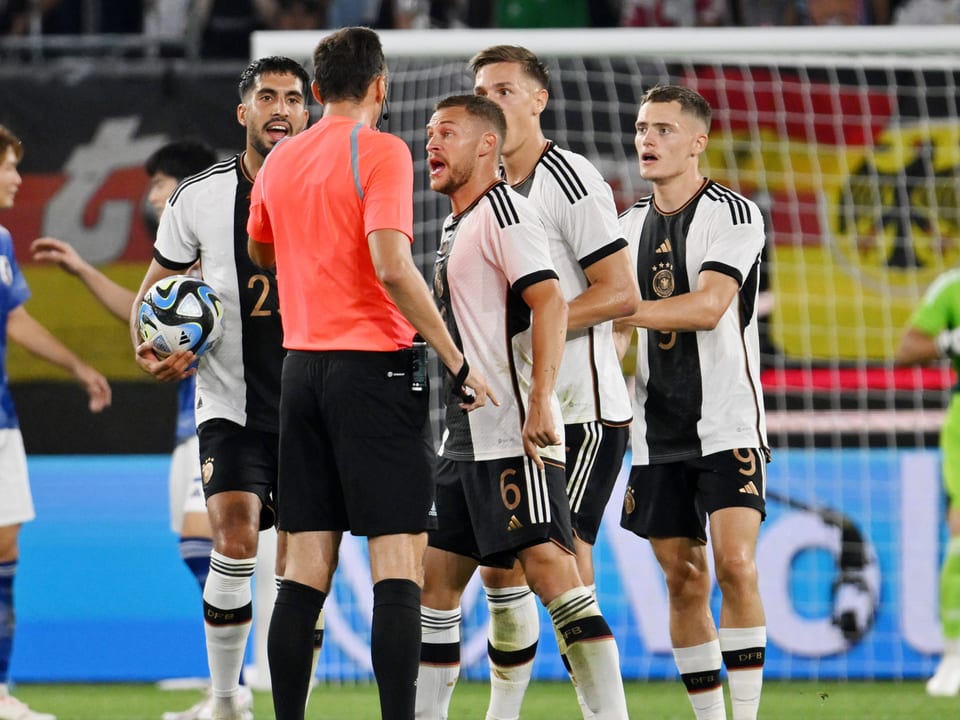 Vier deutsche Spieler bedrängen den Schiedsrichter.