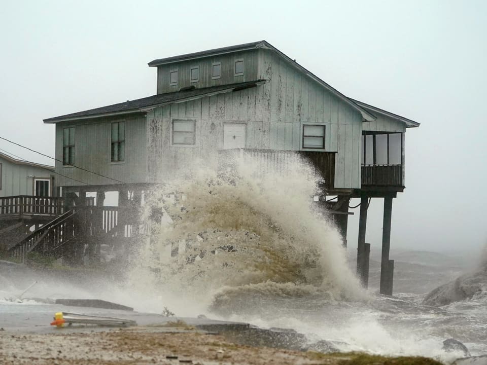 Wellen umspülen ein Haus.