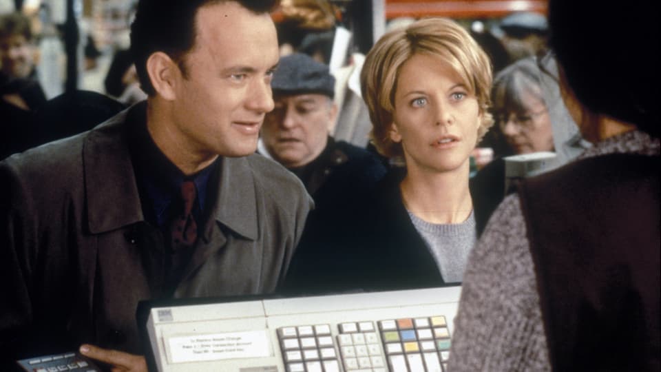 Tom Hanks und Meg Ryan stehen an einer Kasse.