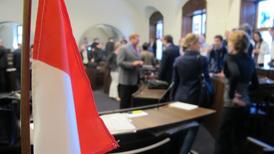 Solothurner Flagge im Vordergrund, diskutierende Parlamentarier im Hintergrund.