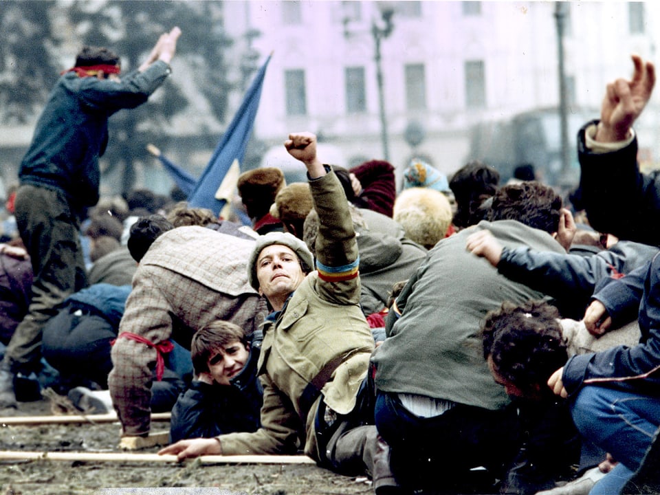 Demonstrant am Boden liegend, die geballte Faust in die Luft streckend.