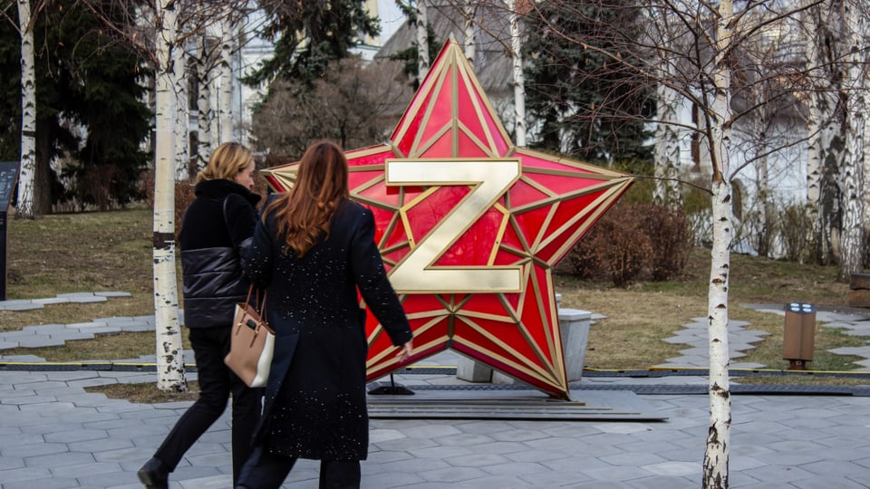 Frauen laufen im Moskau an «Z»-Symbol auf Sowjetstern vorbei