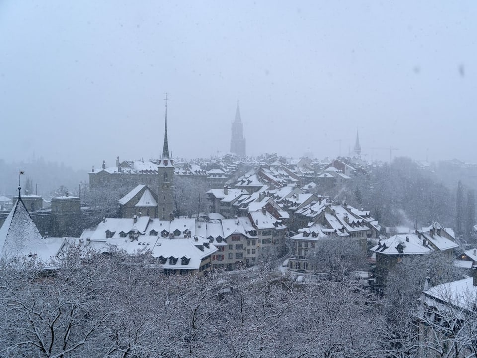 Blick von oben auf die verschneite Stadt Bern.