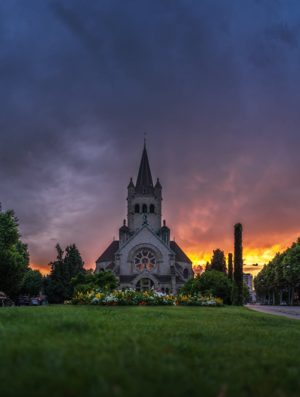 Basel Stadt Pauluskirche mit leutendem Sonnenuntergang und grauen Gewitterwolken