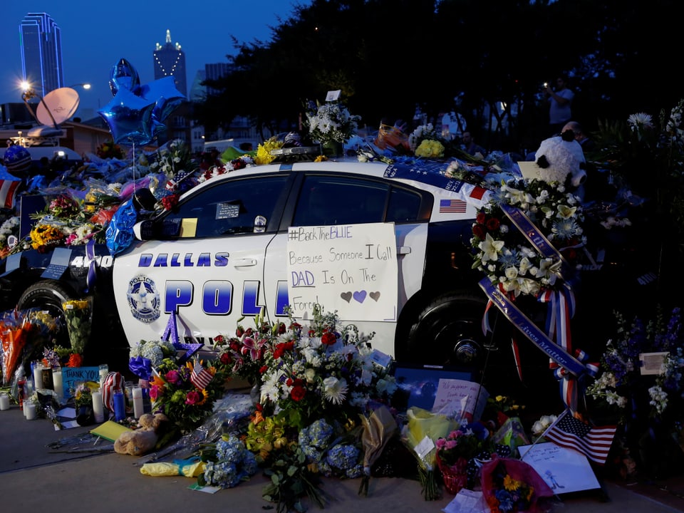 Ein Auto vor dem Polizei-Hauptquartier in Dallas ist mit Blumen und Briefen übersät