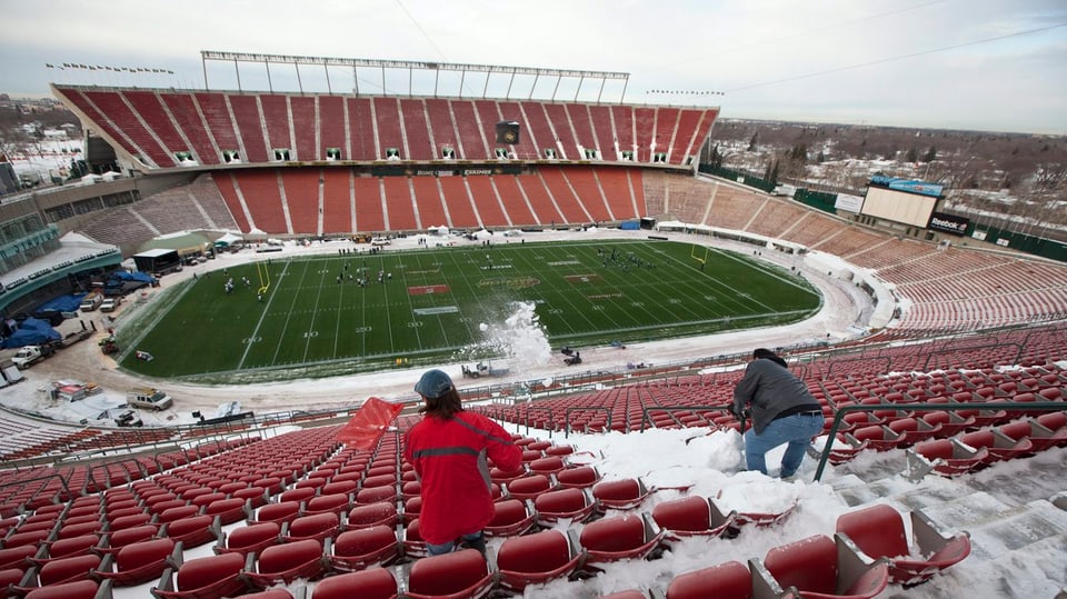 Die Sitzreihen im Commonwealth Stadium in Edmonton wird von Helfern vom Schnee befreit.