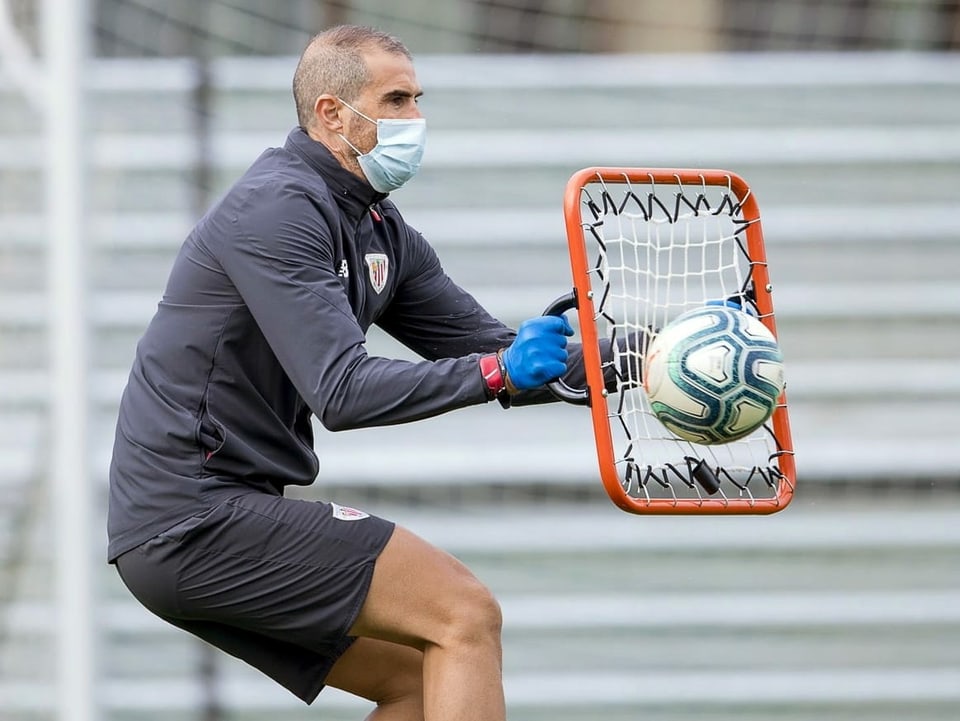 Trainer trainiert mit Schutzmaske und Handschuhe