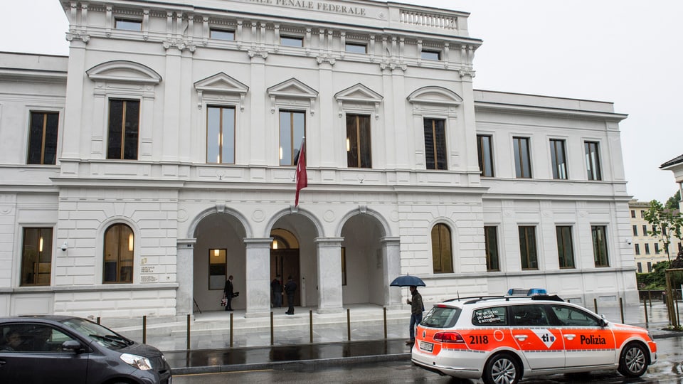 Aussenansicht des Bundesstrafgerichts in Bellinzona bei Regen. Ein Polizeiauto davor.