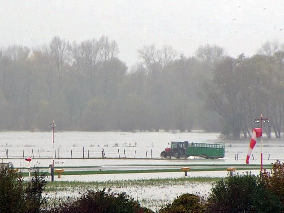 Ein Traktor fährt auf einem überschwemmten Feld
