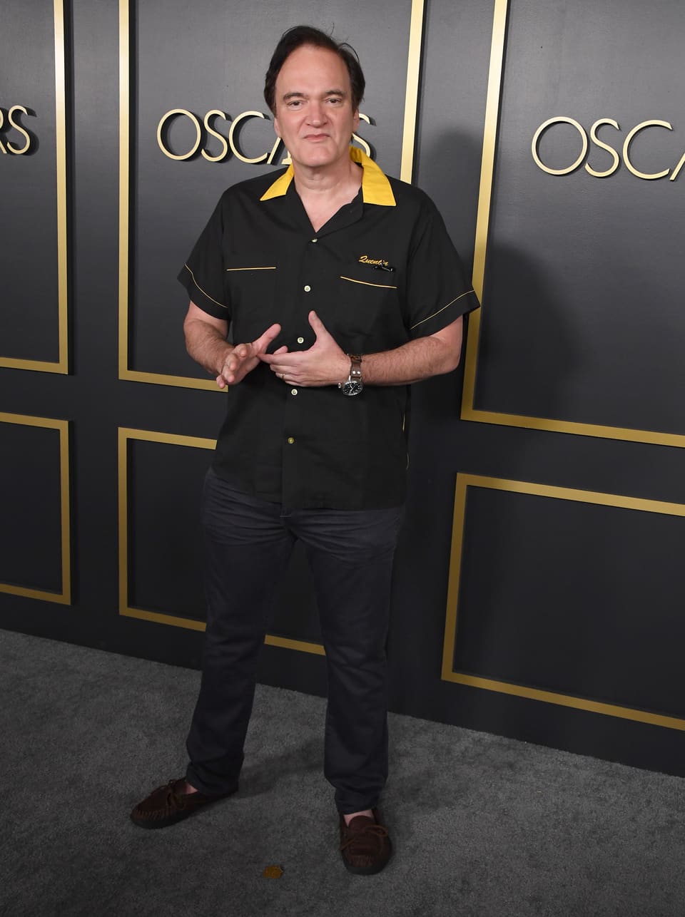 Mann vor einem schwarzen Hintergrund mit der goldenen Aufschrift «Oscars».