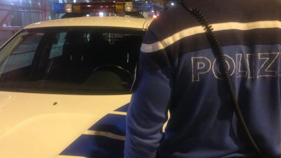 Ein Oltner Stadtpolizist vor einem Polizeiauto.