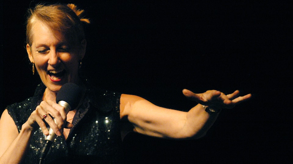 Die Sängerin Lauren Newton singt in ein Mikrofon.