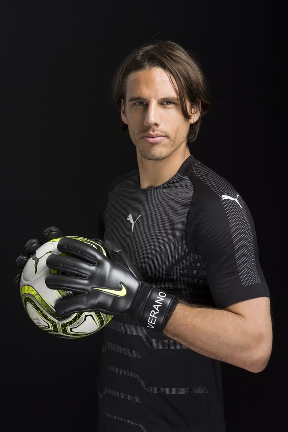 Yann Sommer mit einem Fussball in den Händen vor einem dunklen Hintergrund. 