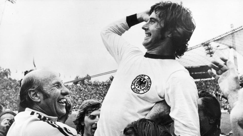 Gerd Müller im Jahr 1974, wie er nach dem siegbringenden Tor von Trainer und Mannschaftskollegen hochgehoben wird.