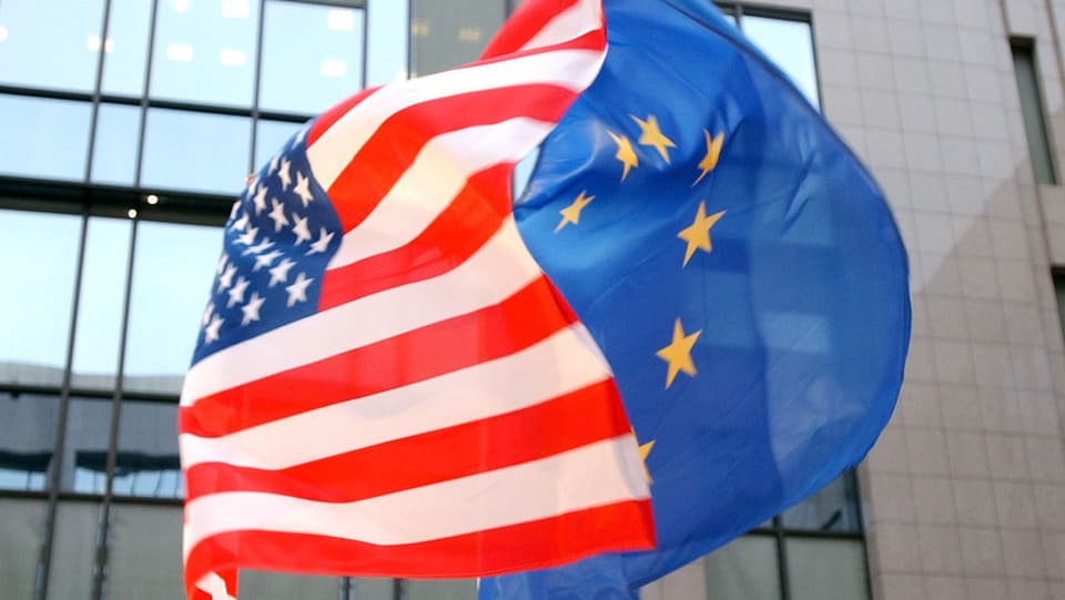 Symbolbild: Eine US- und eine EU-Fahne wehen im Wind.