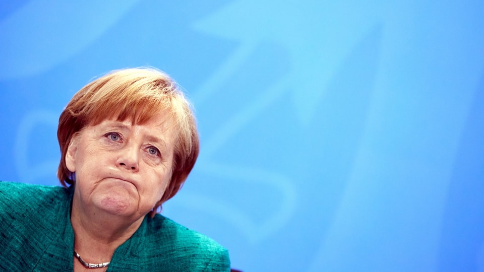 Merkel presst die Lippen zusammen.