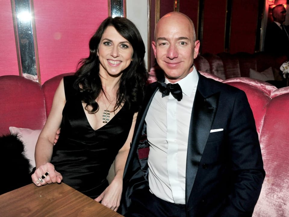 Jeff Bezos mit dem Arm um seiner Ex-Frau in die Kamera lächelnd
