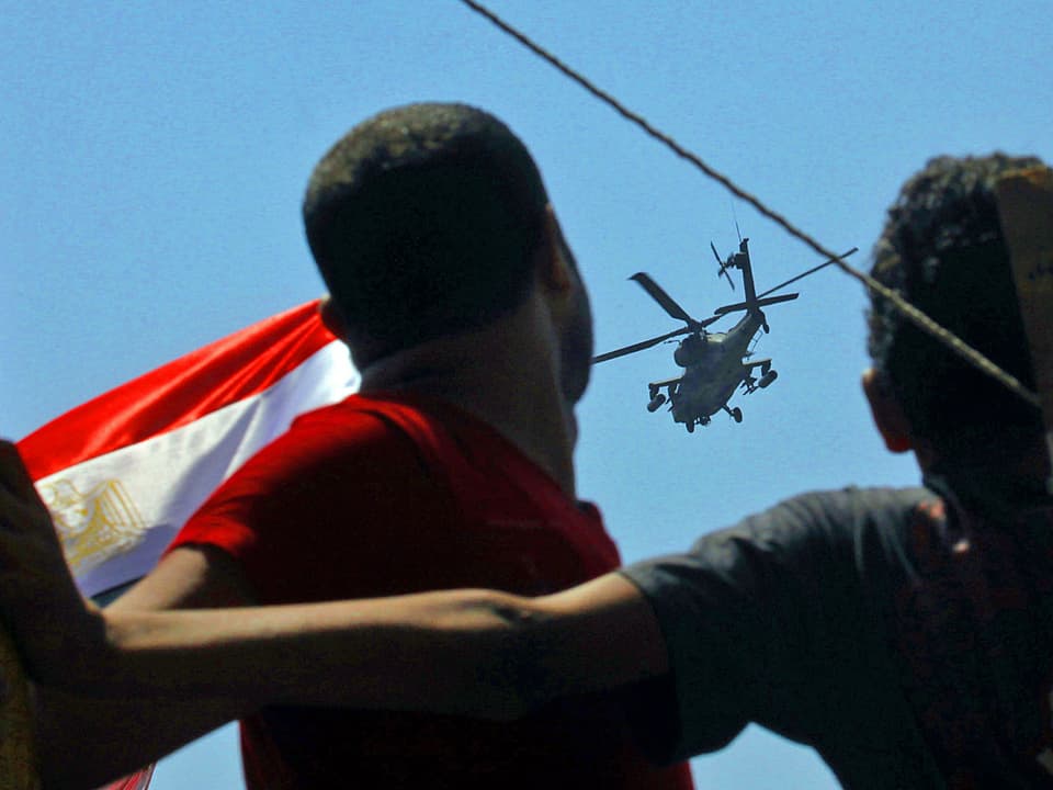 Hubschrauber über den Köpfen von Demonstranten.