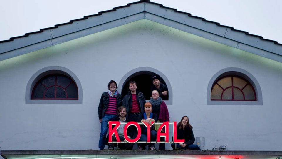 Menschen auf einem Dach mit dem Schriftzug Royal