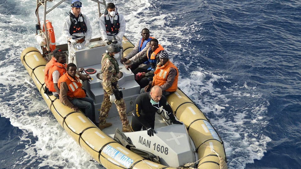 Helfer und Flüchtlinge auf Rettungsboot