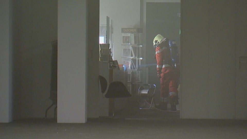 Ein Feuerwehrmann in einem rauchgefüllten Raum.