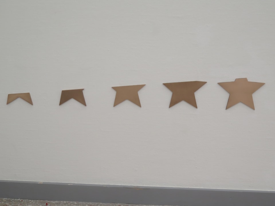 Fünf goldene, horizontal abgeschnittene Sterne.