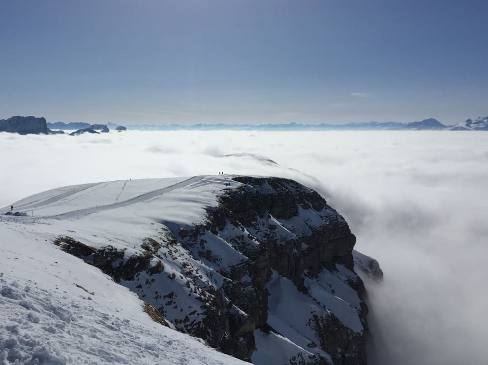 Nebelmeer, blauer Himmel und verschneite Berge