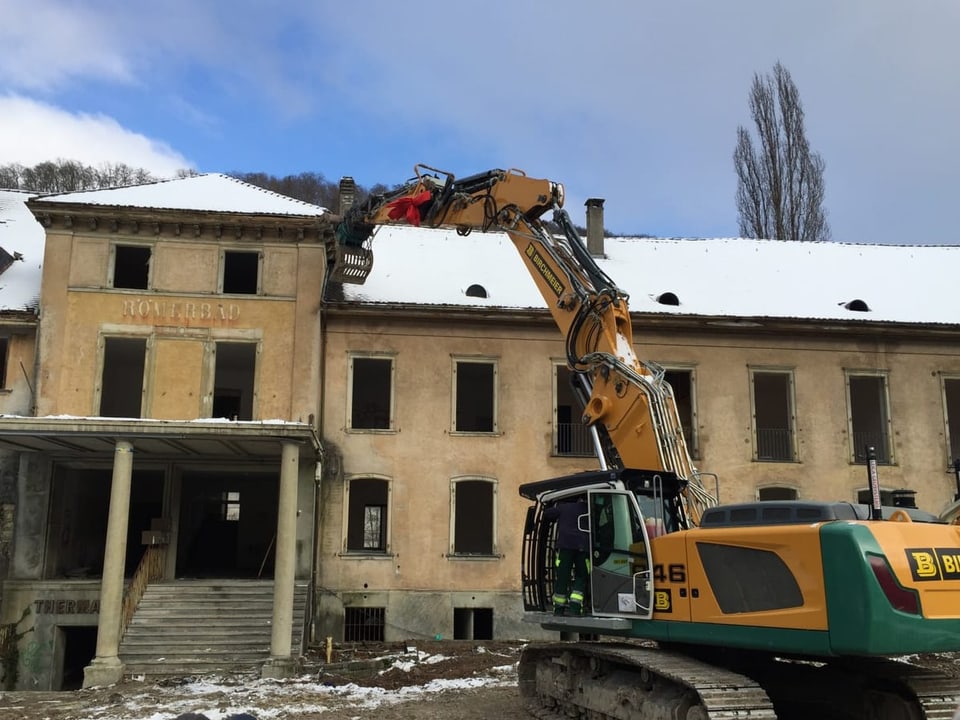 Bagger reisst Gebäude ab.