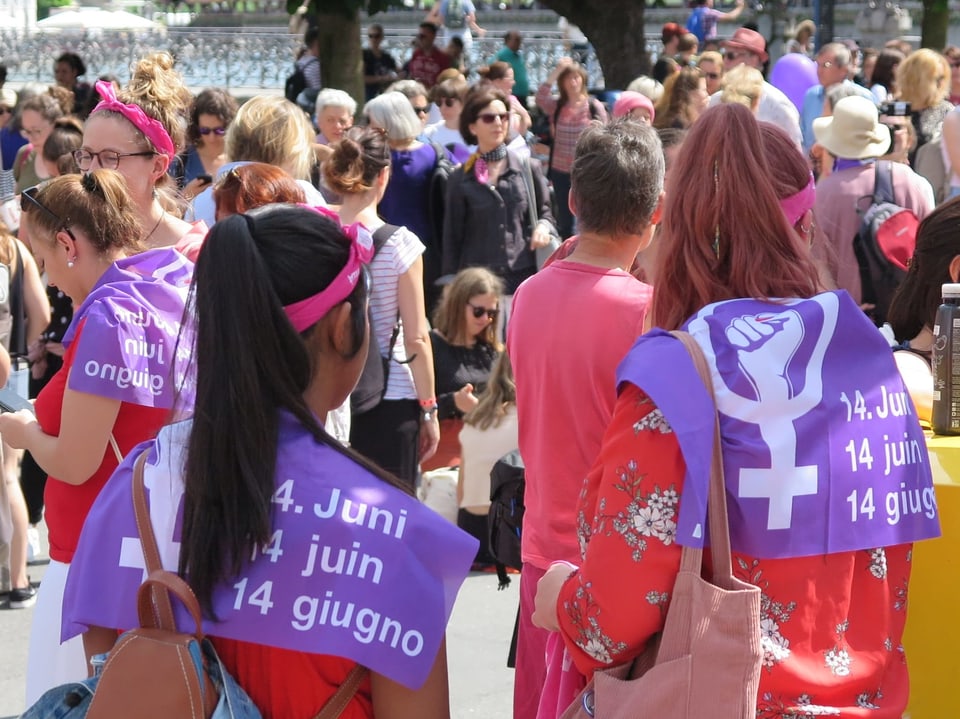 Junge Frauen tragen die Frauenstreikfahne als Umhang.