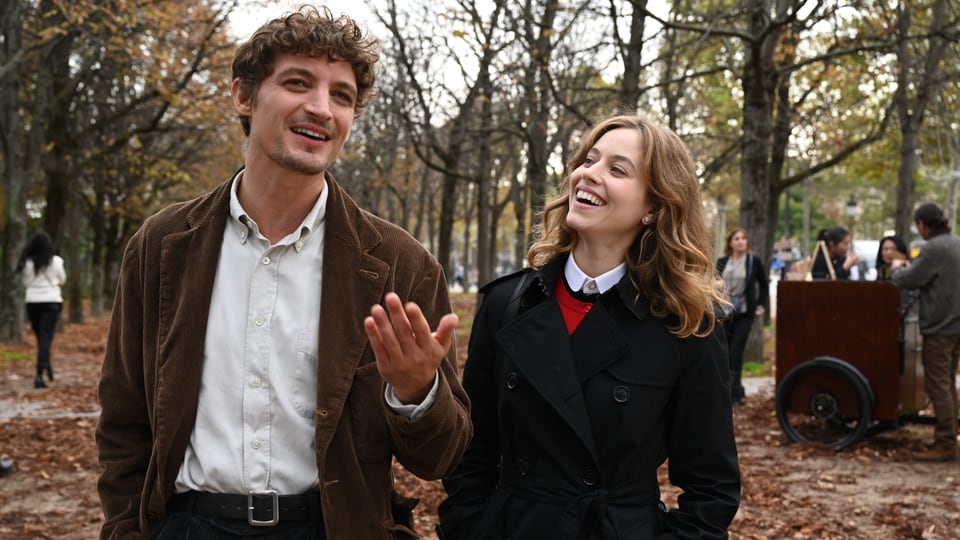 Ein Frau und ein Mann in einem Park spazierend und lachend.