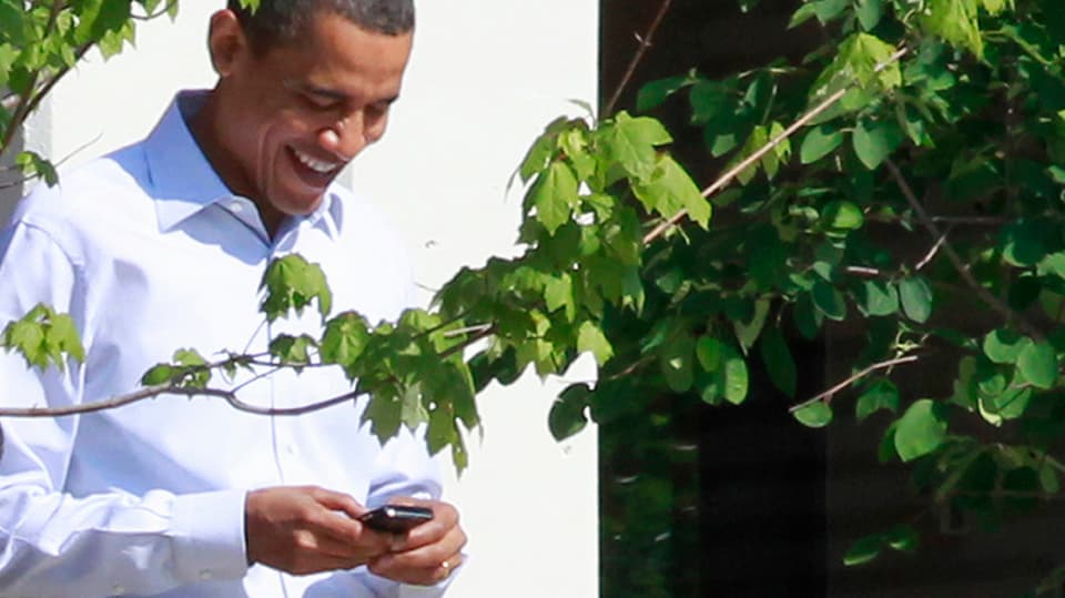 US-Präsident Barack Obama beschäftigt sich mit seinem Handy.