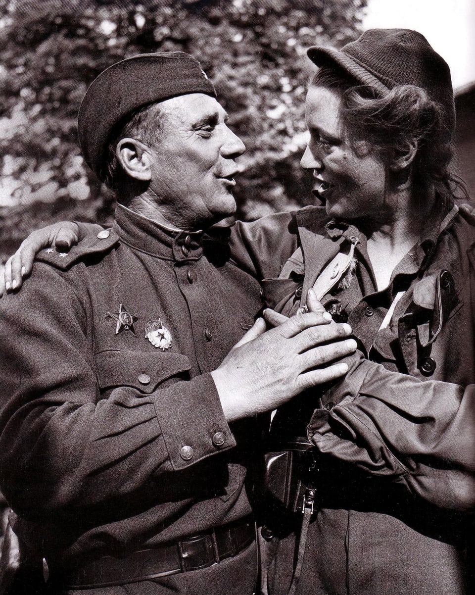 Ein Mann und eine Frau in Uniform die Hände über die Schultern gelegt.