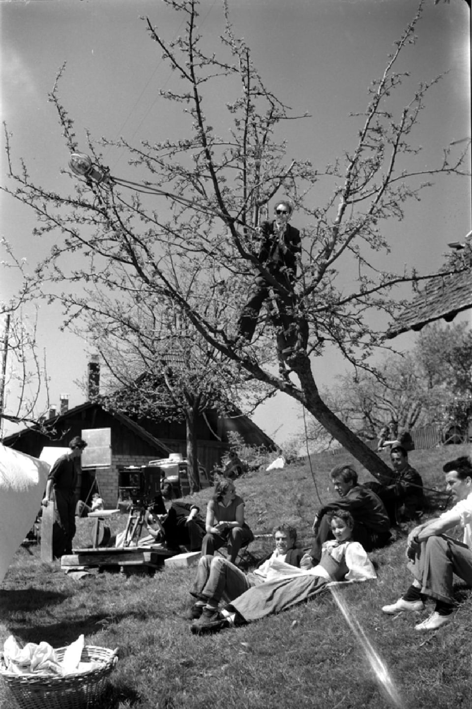 Aussenaufnahmen unter einem blühenden Kurschbaum. Die Kamera steht darunter, die Schauspieler liegen im Grad davor. Der Tonmann steht mit der Tonangel auf einem Ast im Baum
