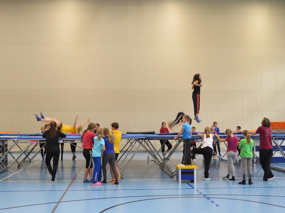 Kinder hüpfen auf Trampolin in Turnhalle