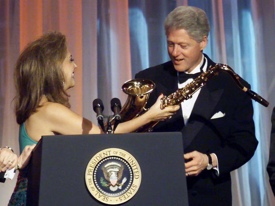 Richs Exfrau Denise gibt Bill Clinton ein Saxophon