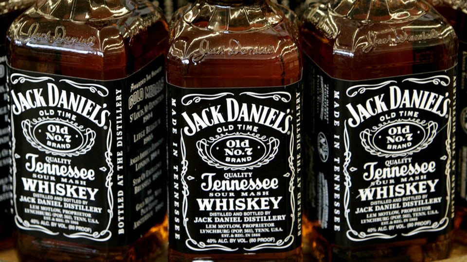 Drei volle Flaschen Whiskey der Marke Jack Daniel's nebeneinander.