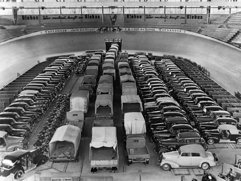 Beschlagnahmte Privatautos werden im 2. Weltkrieg im Hallenstadtion parkiert.