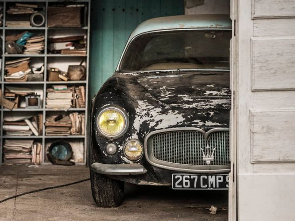Ein Maserati, befleckt mit Vogelkot steht in einer Scheune.