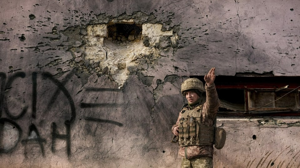 Ein ukrainischer Soldat neben einem Gebäude, das beschossen wurde in der Region Luhansk.