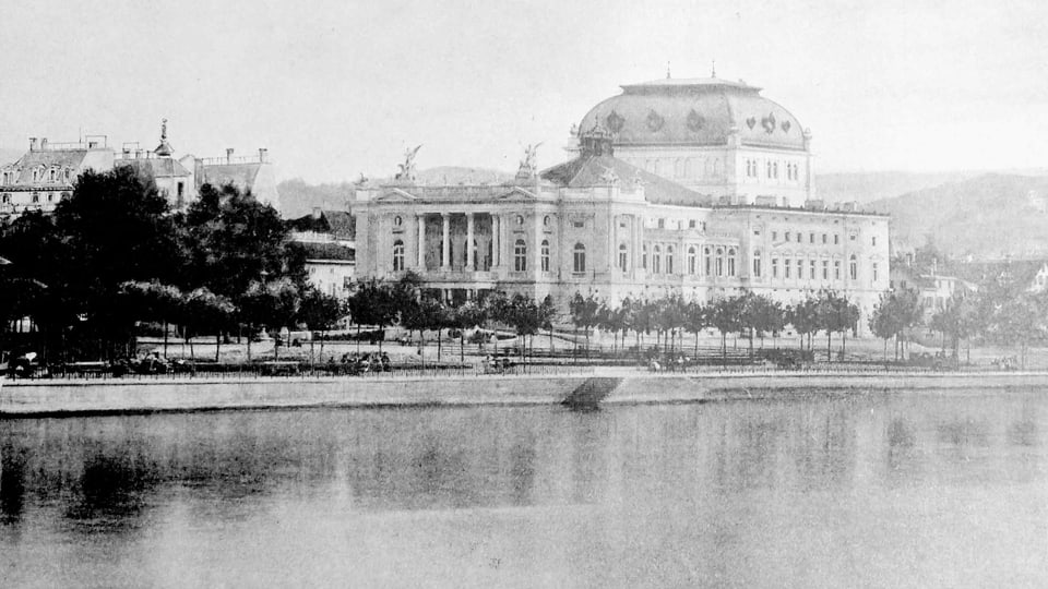 Schwarz-weiss Fotografie eines grossen Gebäudes am See.