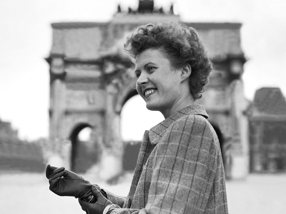 Eine junge Frau vor dem Arc de Triomphe.