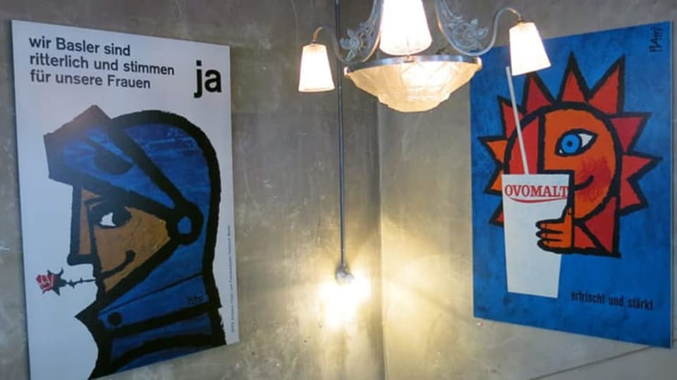 zwei Plakate hängen an einer Wand
