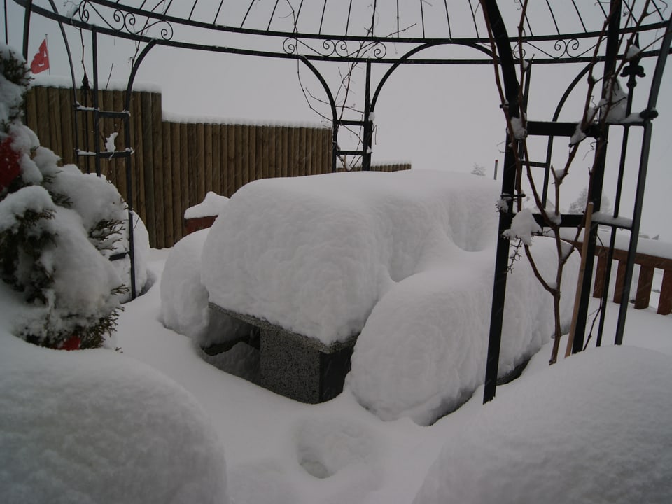 Ein Gartentisch, tief verschneit.