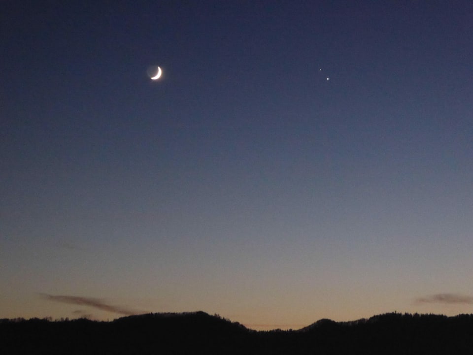 Mond, Saturn und Jupiter am Abendhimmel.