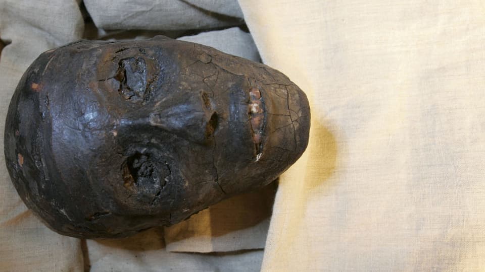 Die Mumie von Tunanchum unter einem weissen Tuch.