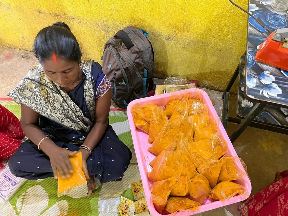 Woman on the ground with bags of turmeric