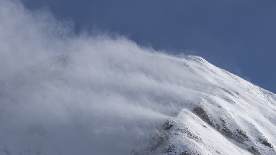 The wind blows a lot of snow onto the summit