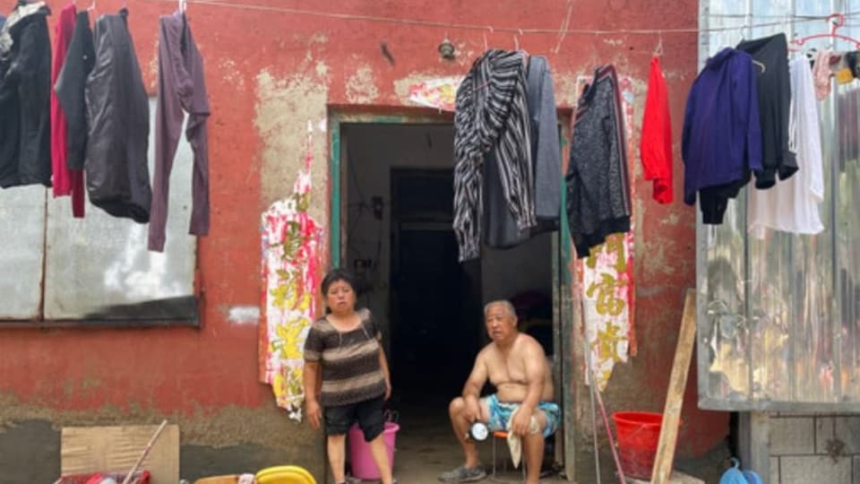 Herr und Frau Huang vor ihrem Hauseingang. Der erste Stock wurde komplett überschwemmt.