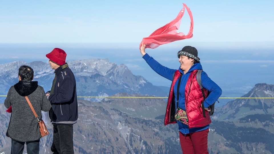 Eine chinesische Touristen schwing ein rotes Tuch auf dem Gipfel des Titlis.