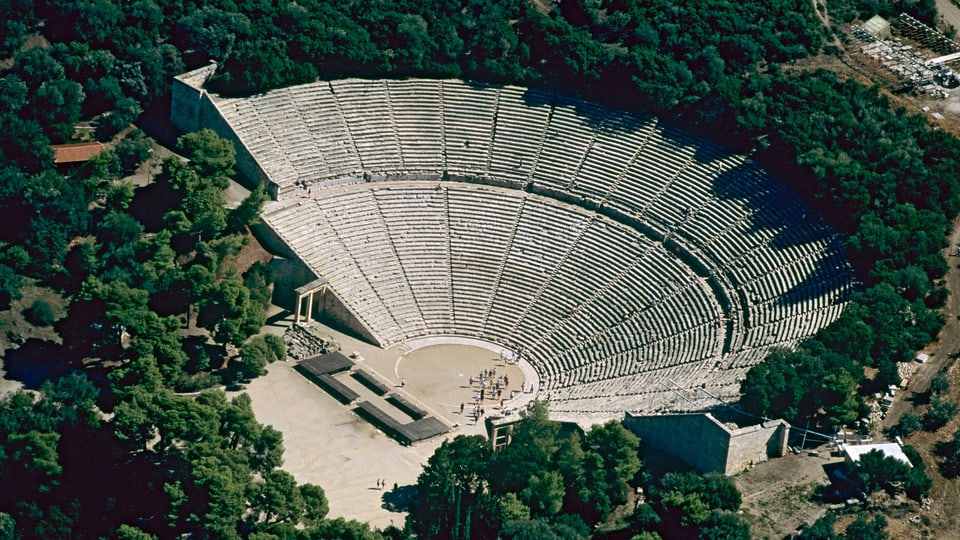 Ein riesiges Amphitheater, umgeben von Bäumen.